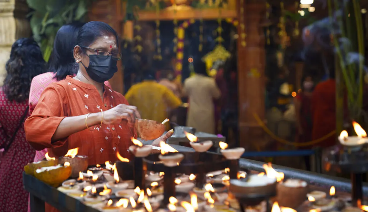 Umat Hindu menyalakan lampu minyak saat berdoa selama Festival Diwali di Kuil Batu Caves, Kuala Lumpur, Malaysia, Kamis (4/11/2021). Diwali adalah salah satu festival terpenting dalam agama Hindu, didedikasikan untuk penyembahan dewi kekayaan Lakshmi. (AP Photo/Vincent Thian)