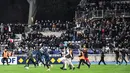 Suporter berlarian di lapangan pada babak pertama pertandingan 64 besar Piala Prancis antara Paris FC dan Olympique Lyon di stadion Charlety, Paris, Jumat (17/12/2021). Laga Paris FC dan Olympique Lyon dihentikan setelah penonton rusuh di stadion. (Bertrand GUAY/AFP)