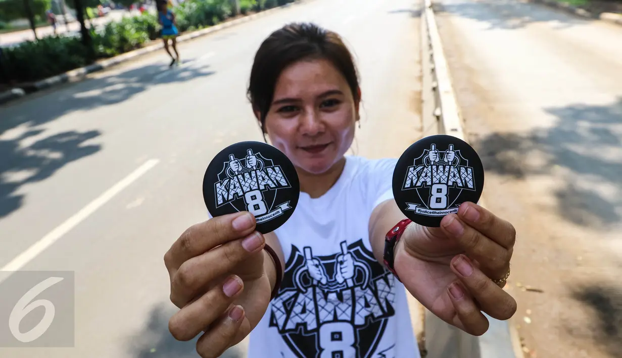 Seorang pemudi menunjukkan PIN berlogo kawan8 saat Car Free Day di kawasan Senayan, Jakarta Minggu (24/7). Mereka juga mengajak masyarakat untuk bisa berlaku adil dalam segala hal. (Liputan6.com/Fery Pradolo)