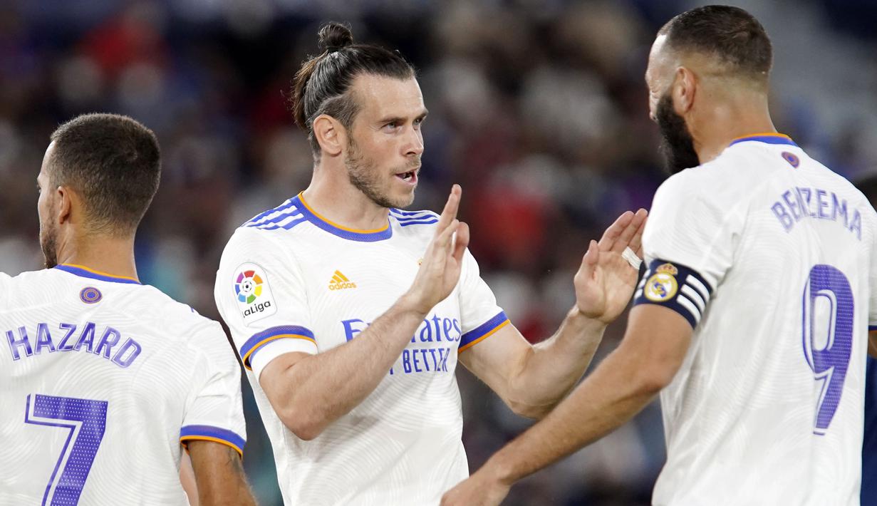 <p>Los Blancos membuka kedudukan terlebih dahulu lewat gol cepat Gareth Bale (kiri) ketika babak pertama baru berjalan lima menit. Bale sukses menuntaskan umpan Benzema meski dirinya dikawal oleh dua pemain. Papan skor berubah menjadi 1-0 atas keunggulan Real Madrid. (Foto: AP/Alberto Saiz)</p>