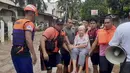 Seorang wanita tua duduk di kursi sambil digendong oleh personel penjaga pantai yang mengarungi banjir di Plaridel, provinsi Misamis Occidental di Filipina selatan, Senin, 26 Desember 2022. Hujan lebat dan banjir menghancurkan beberapa bagian Filipina. (Philippine Coast Guard via AP)