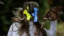 Anak-anak dengan pita warna nasional Ukraina di rambut mereka bermain di perayaan hari Kemerdekaan Ukraina di sebuah perayaan di Chichester, Inggris selatan, Sabtu, 27 Agustus 2022. Chichester dinobatkan sebagai daerah paling dermawan di negara itu untuk menampung pengungsi Ukraina. (AP Photo/Frank Augstein)