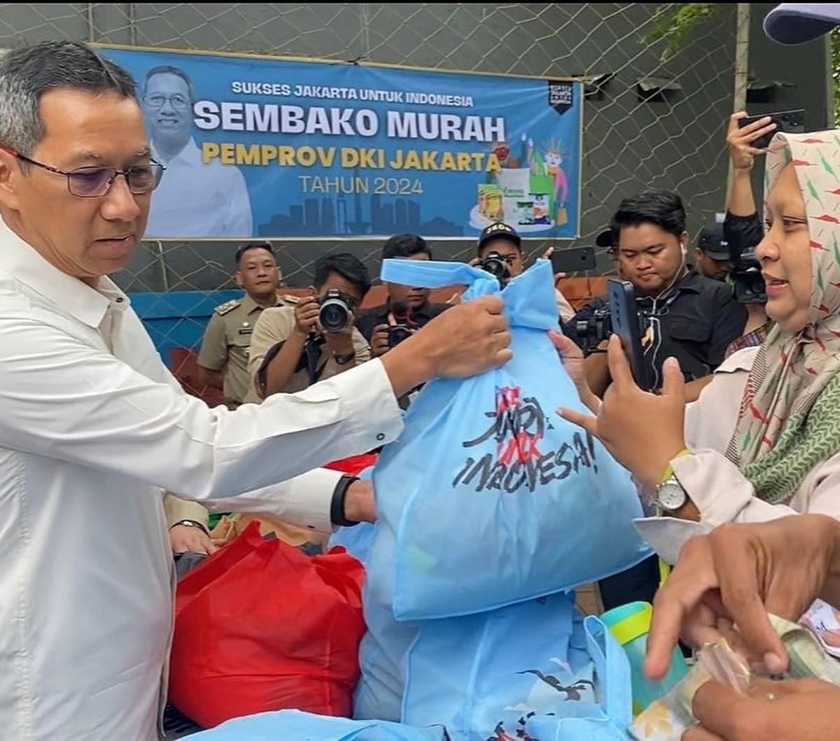 Dalam foto yang dibagikan, Heru terlihat tengah membagikan Bansos kepada warga berupa sembako yang dibungkus di dalam tas berwarna biru muda.