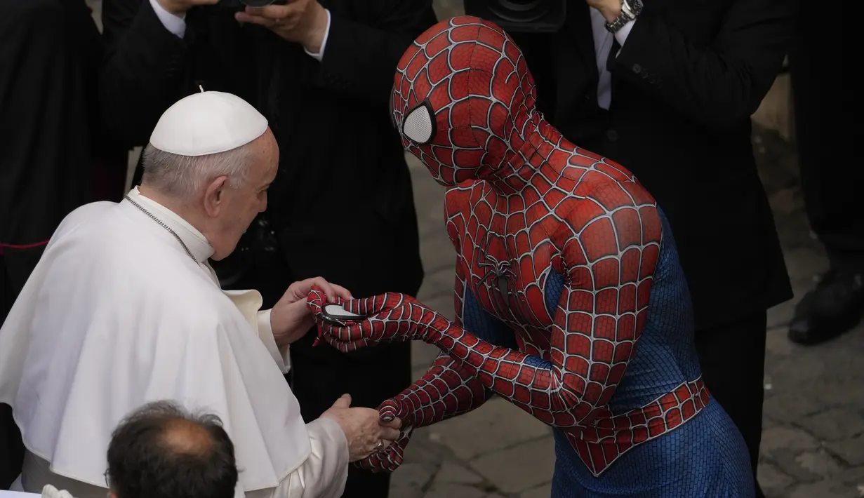 Paus Fransiskus bertemu Spider-Man, yang memberinya masker, pada akhir audiensi umum mingguan dengan jumlah umat terbatas di San Damaso Courtyard, Vatikan, Rabu (23/6/2021). Pria itu adalah Mattia Villardita (27) dari Italia utara yang menghibur anak-anak di rumah sakit. (AP Photo/Andrew Medichini)