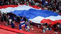 Pendukung Thailand mengibarkan bendera pada Piala AFF 2020. (AFP/Roslan Rahman)