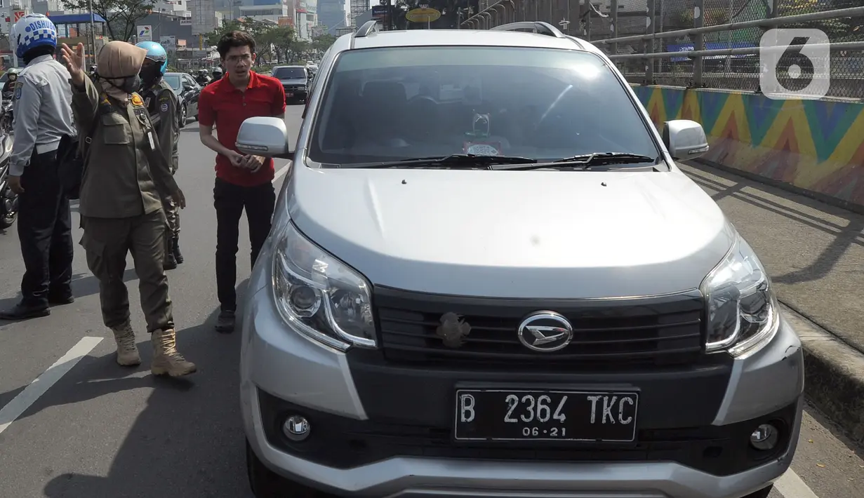 Petugas Satpol PP memberhentikan pengendara mobil yang tidak mengenakan masker di kawasan Jalan Ir. H. Juanda, Depok, Jawa Barat, Kamis (23/7/2020). Sejumlah pengendara dan penumpang angkutan umum terjaring razia Gugus Tugas Percepatan Penanganan COVID-19 Kota Depok. (merdeka.com/Arie Basuki)