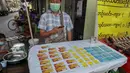 Seorang pedagang kaki lima memamerkan kartu SIM seluler di Yangon, Myanmar (4/2/2021).  Pemerintah militer baru Myanmar telah memblokir akses ke Facebook karena perlawanan terhadap kudeta yang melonjak di tengah seruan pembangkangan sipil. (AP Photo)