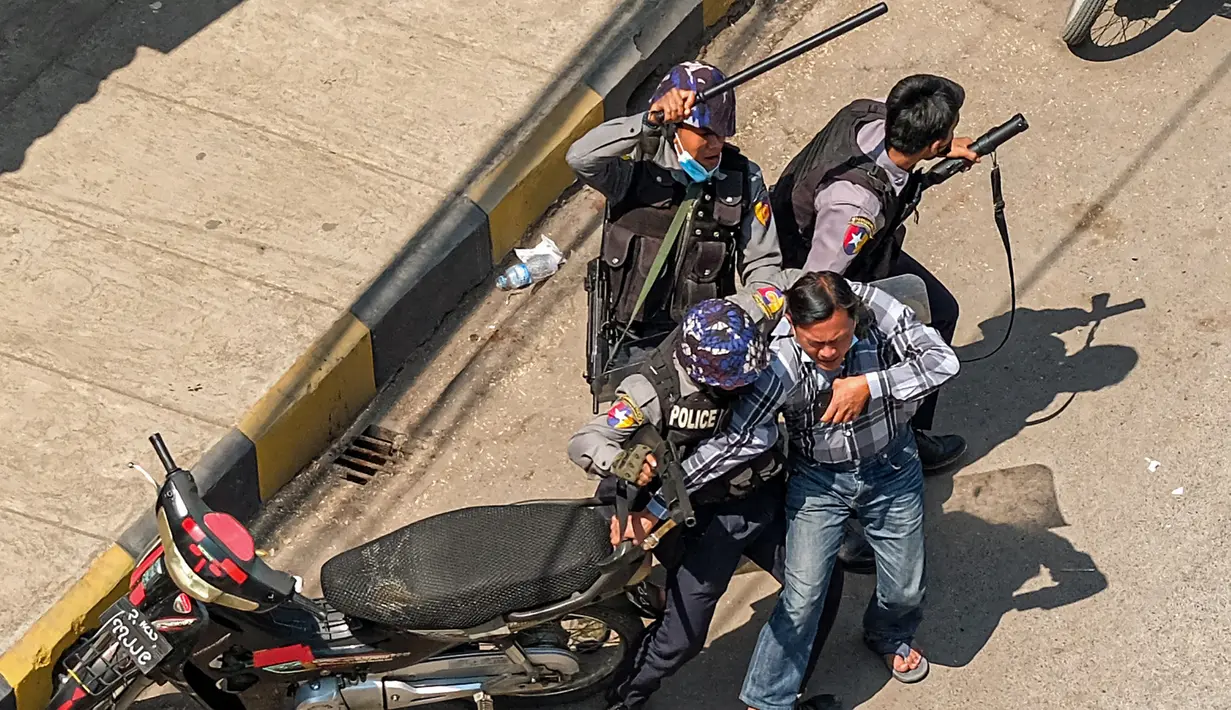Polisi menangkap seorang pria di Taunggyi, sebuah kota di Negara Bagian Shan (28/2/2021).  Sedikitnya 18 orang tewas setelah Polisi Myanmar menembaki pengunjuk rasa di seluruh negeri pada hari Minggu. (AFP/STR)