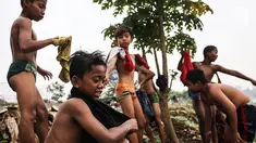 Seorang anak mencari biawak di tepi Sungai Banjir Kanal Barat, Petamburan, Jakarta, Jumat (9/11). Mendung yang menyelimuti ibukota Jakarta, tidak menyurutkan anak-anak bermain di Sungai Banjir Kanal Barat. (Liputan6.com/Fery Pradolo)