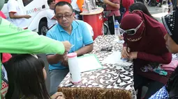 Warga mengisi formulir untuk membayar pajak kendaraan bermotor di gerai Samsat Keliling Car Free Day, Jakarta, Minggu (21/10). Agar bisa membayar pajak ini cukup menggunakan STNK dengan nama yang tertera harus sesuai KTP. (Liputan6.com/Angga Yuniar)