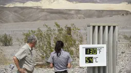 Staf memfoto termometer yang menunjukkan suhu 54 Derajat Celcius di Pusat Pengunjung Furnace Creek di Taman Nasional Death Valley, California, Kamis (17/6/2021). National Park Service memperingatkan panas musim panas yang ekstrem, mendesak wisatawan untuk membawa air ekstra. (Patrick T. FALLON/AFP)