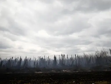Asap mengepul dari area terbakar pada Highway 63 selatan dari Fort McMurray, Alberta, Kanada, (9/5). Sekitar 80 ribu warga Kanada terpaksa dievakuasi Akibat kebakaran dahsyat di seluruh kota ini. (REUTERS/Chris Wattie)