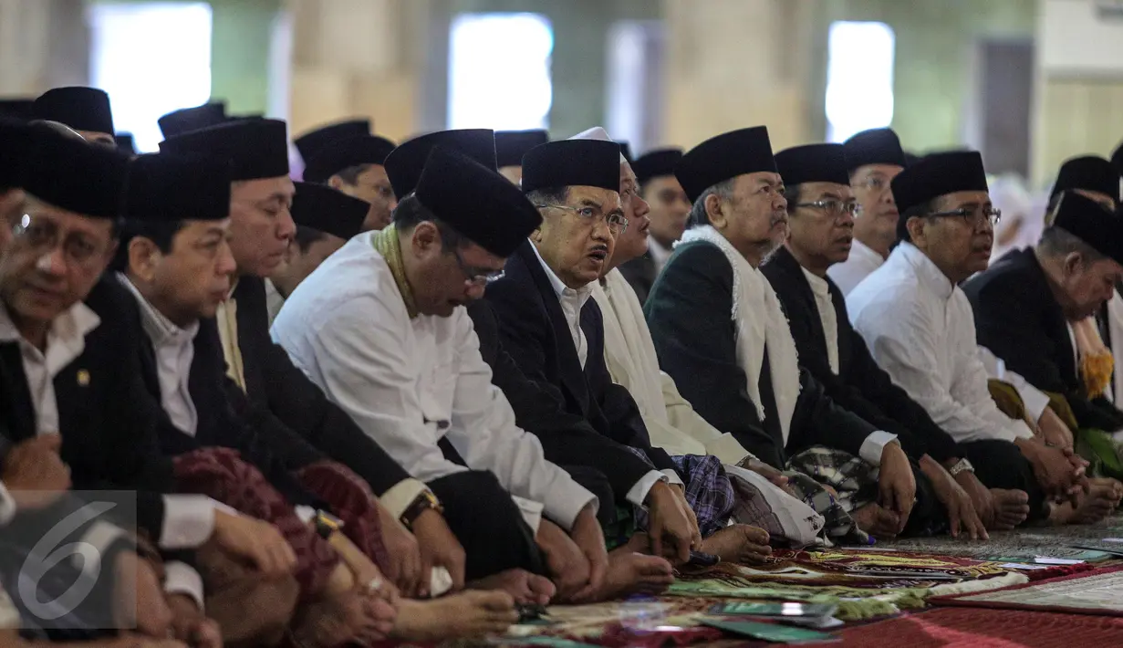Wakil Presiden Jusuf Kalla (tengah) bersama ribuan umat muslim melakukan salat Idul Fitri di Masjid Istiqlal, Jakarta, Jumat (17/7/2015).  Tampak, Wakil Presiden Jusuf Kalla duduk bersama sejumlah pejabat tinggi negara. (Liputan6.com/Faizal Fanani)