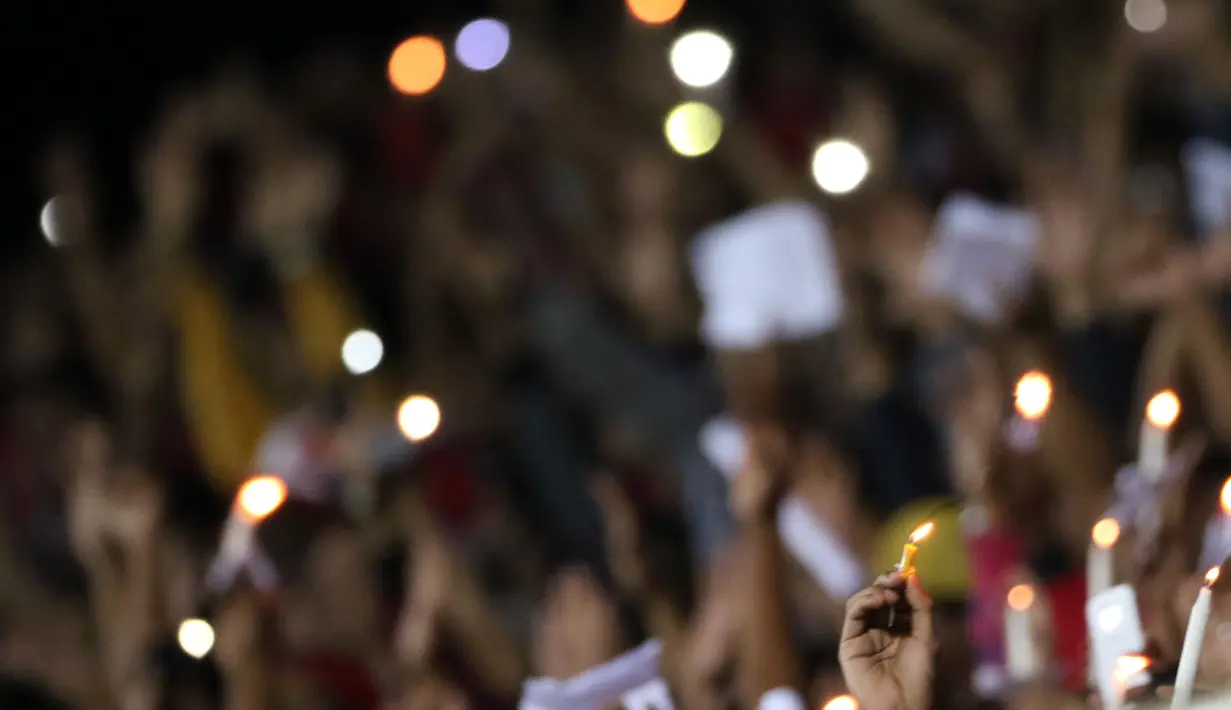 Suporter Persipura menyalakan lilin sebagai tanda dukungan kepada timnya pada lanjutan Piala Jenderal Sudirman grup E  di Stadion Sleman, Yogyakarta, Minggu (13/12/2015). (Bola.com/Nicklas Hanoatubun)