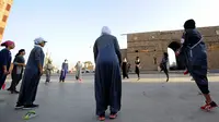 Perempuan Arab Saudi pemanasan sebelum jogging dalam memperingati Women's Day atau Hari Perempuan Internasional di Distrik Al-Balad, Jeddah, Kamis (8/3). Perempuan Arab Saudi menyambut baik sejumlah kebebasan yang diberikan. (Amer HILABI/AFP)