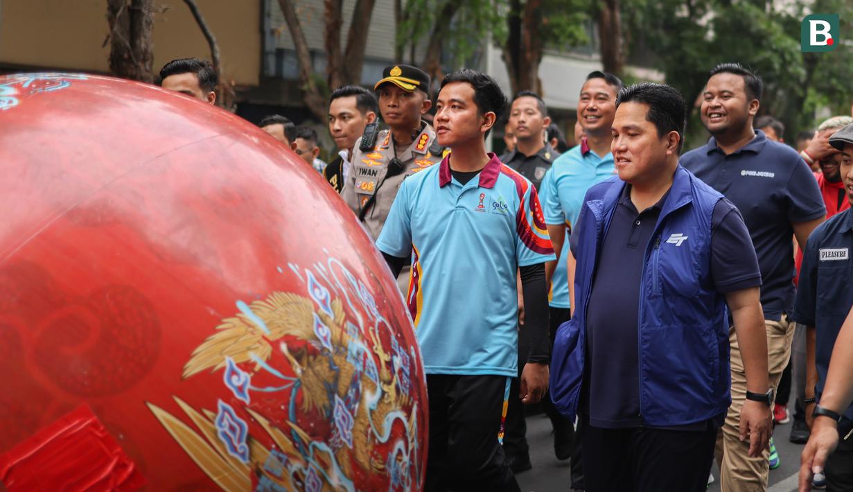 Ketua Umum PSSI, Erick Thohir dan Walikota Solo, Gibran Rakabuming Raka larut dalam pawai Trophy Experience Piala Dunia U-17 2023 bersama ribuan warga Surakarta yang memadati jalan dari Stadion Sriwedari menuju kawasan Pura Mangkunegaraan. (Bola.com/Radifa Arsa)