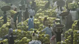 Pedagang berkumpul di pasar buah dini hari di tengah kondisi kabut asap di Lahore, Pakistan, Senin (8/11/2021). Lahore menjadi salah satu kota paling tercemar di dunia. (Arif ALI/AFP)