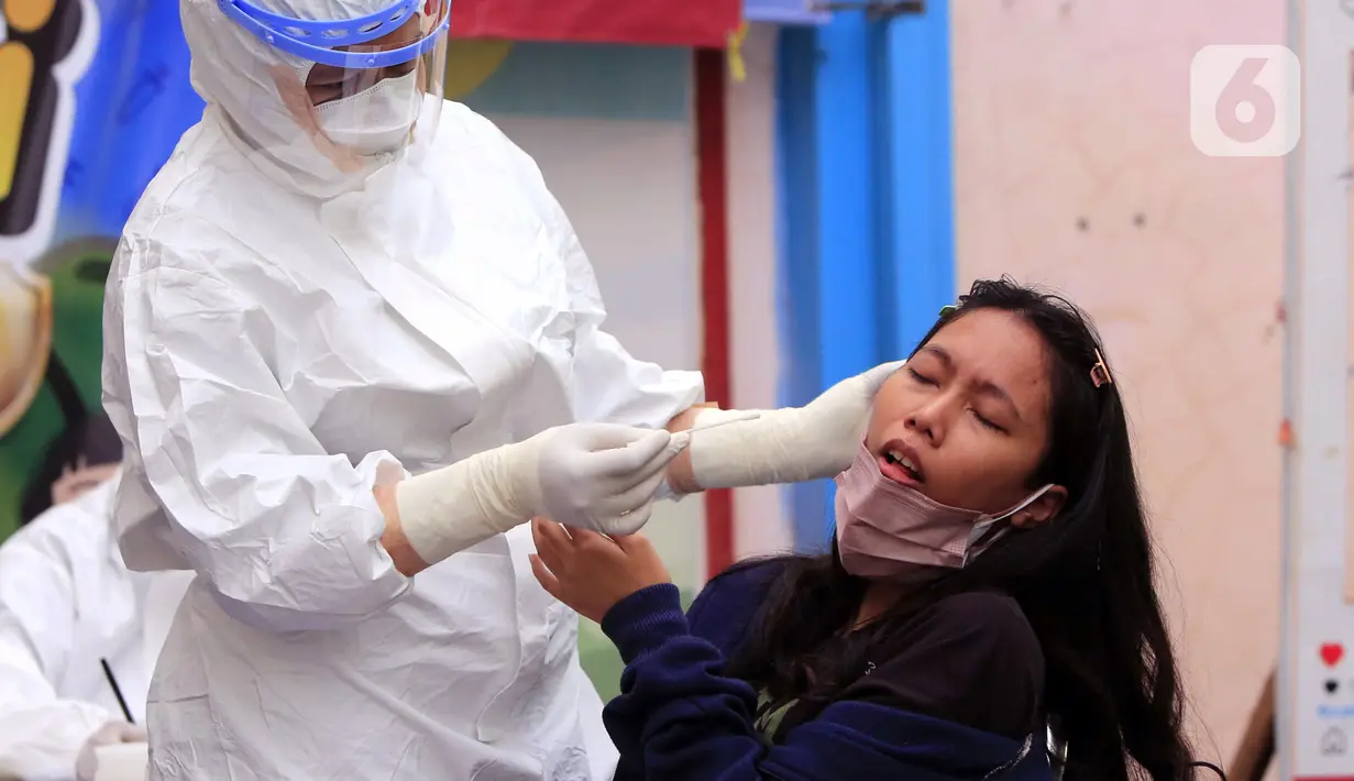 Tenaga kesehatan melakukan tes PCR COVID-19 kepada warga di Puskesmas Cipadu, Tangerang, Banten, Selasa (22/2/2022). Menurut Menteri Kesehatan Budi Gunadi Sadikin, proporsi kenaikan kasus COVID-19 di luar Jawa-Bali terus naik. (Liputan6.com/Angga Yuniar)