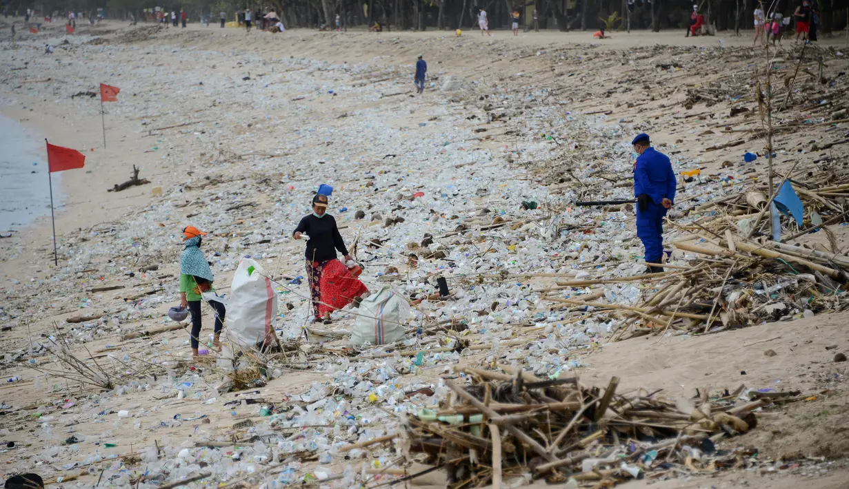 Pemandangan sampah kiriman yang terdampar memenuhi pesisir pantai Kuta, Bali, Kamis (31/12/2020). Pantai Kuta tampak sepi menyusul aturan larangan pesta perayaan pergantian tahun baru dan pemberlakuan jam malam untuk pengendalian aktivitas masyarakat yang dibatasi. (SONNY TUMBELAKA / AFP)