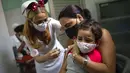 Seorang ibu memegangi putrinya yang disuntik dengan dosis vaksin COVID-19 Soberana-02, di Havana, Kuba, Kamis (17/9/2021). Pemerintah Kuba memulai vaksinasi Covid-19 bagi anak-anak berusia 2 tahun dengan vaksin buatan dalam negeri. (AP Photo/Ramon Espinosa)