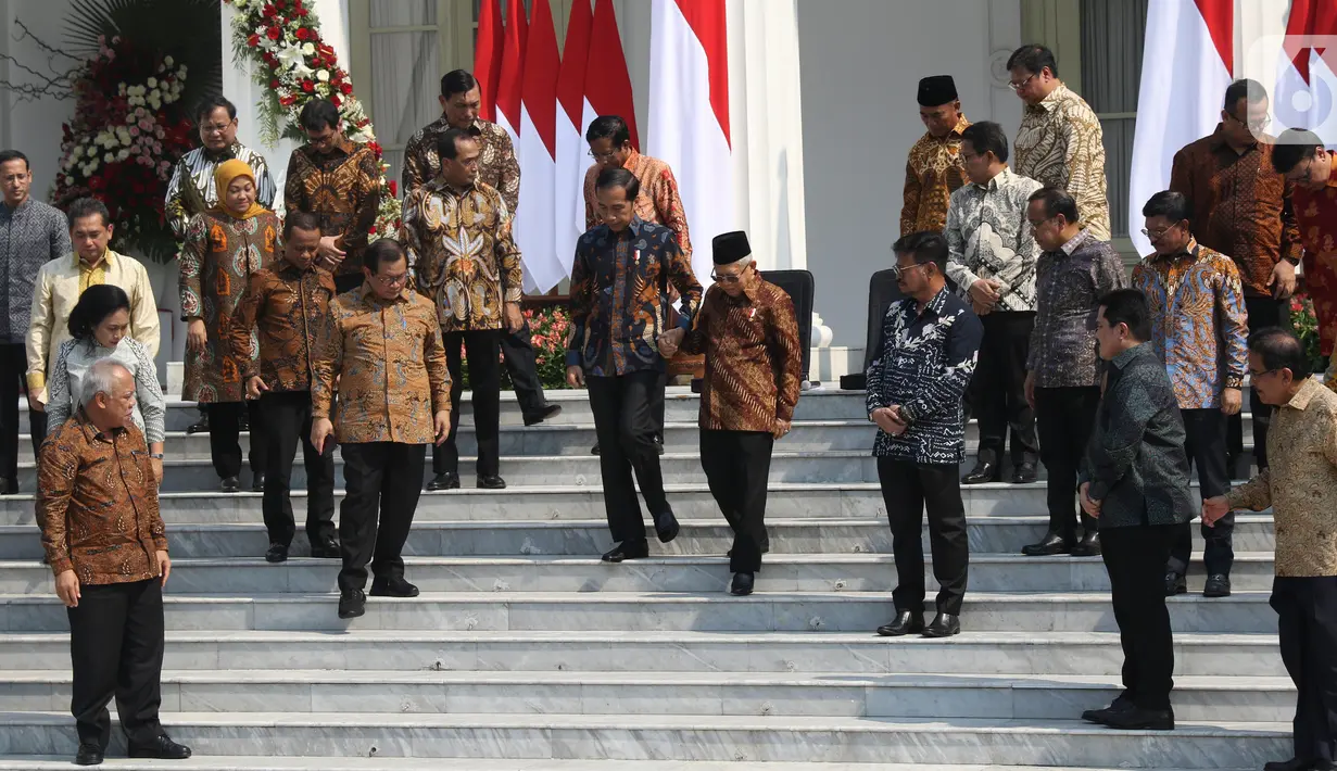 Presiden Joko Widodo (tengah kiri) menggandeng Wakil Presiden Ma'ruf Amin saat menuruni tangga usai memperkenalkan para menteri Kabinet Indonesia Maju di Istana Merdeka, Jakarta, Rabu (23/10/2019). Kabinet Indonesia Maju akan membantu Jokowi-Ma'ruf pada periode 2019-2024. (Liputan6.com/AnggaYuniar)