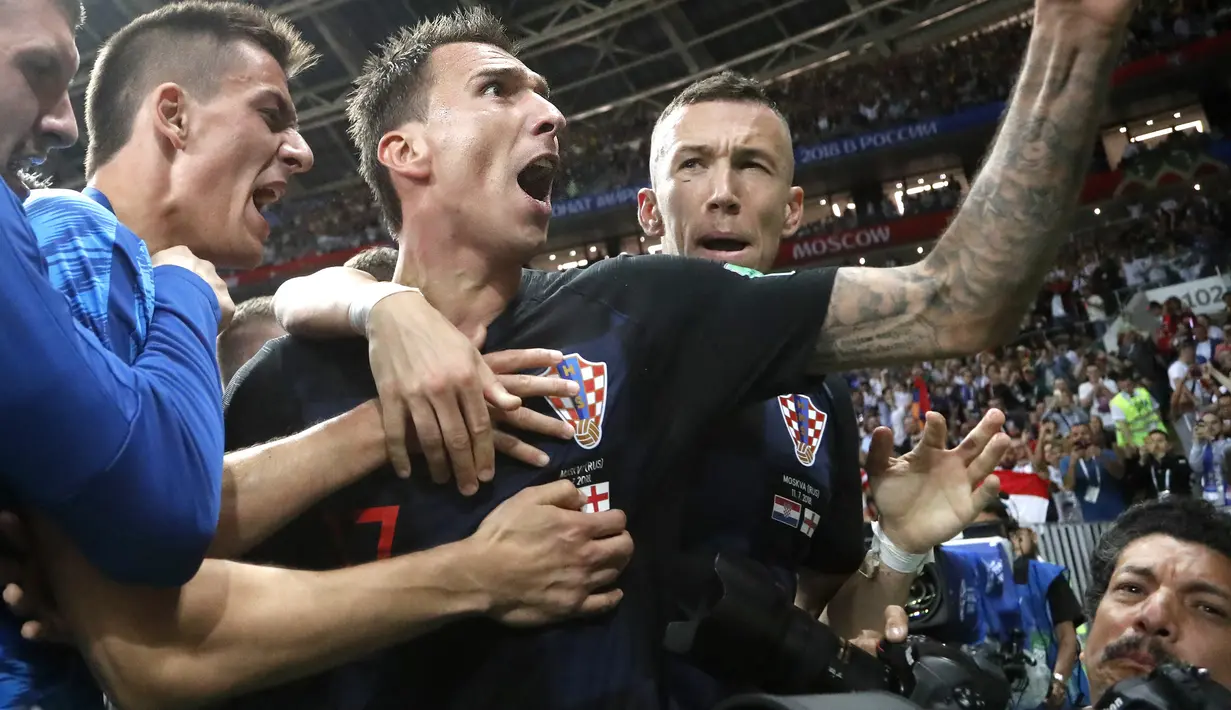 Yuri Cortez (bawah) terjepit saat para pemain Kroasia merayakan gol pada semifinal Piala Dunia 2018 di Luzhniki Stadium, Moskow, (11/7/2018). Yuri jatuh saat perayaan gol skuat Vatreni tersebut. (AP Photo/Frank Augstein)
