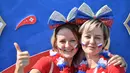Dua wanita mengecat wajahnya dengan bendera Rusia jelang laga antara Uruguay menghadapi Rusia dalam penyisihan Grup A Piala Dunia 2018 di Samara Arena, Samara, Rusia, Senin (25/6). (EMMANUEL DUNAND/AFP)
