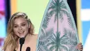 Sambil memegang piala berbentuk papan selancar Chloe Moretz menerima penghargaan sebagai aktris film pilihan: komedi dalam (Neighbors 2: Sorority Rising) (Foto:Chris Pizzello/AP/Bintang.com)