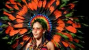 Seorang model berpose di atas catwalk mengenakan busana yang berwarna-warni lengkap dengan aksesoris kepala yang terbuat dari rangkaian dedaunan saat pergelaran Biofashion di Cali, Kolombia (19/11). (Reuters/Jaime Saldarriaga)