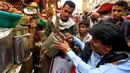 Seorang pembeli melihat kurma yang dijajakan oleh pedagang di sebuah pasar di kota tua Sanaa, Sabtu (11/5/2019). Buah kurma sangat identik saat bulan suci Ramadan, malah menjadi makanan wajib saat berbuka puasa. (Photo by Mohammed HUWAIS / AFP)