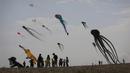 Orang-orang mengambil bagian dalam Varvara Kite Fest di Desa Varvara, pesisir Laut Hitam, Bulgaria, Jumat (27/8/2021). Penyelenggara Varvara Kite Fest Andrey Kulev mengatakan bahwa menerbangkan layang-layang seperti melepaskan semua masalah Anda di langit. (AP Photo/Valentina Petrova)