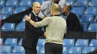 Pelatih Real Madrid Zinedine Zidane berjabat tangan dengan Manajer Manchester City Pep Guardiola usai laga leg kedua babak 16 besar Liga Champions di Etihad Stadium, Sabtu (8/8/2020) dini hari WIB.(Peter Powell / Foto Pool via AP)