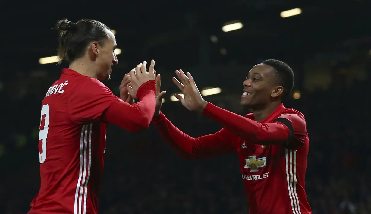 Zlatan Ibrahimovic dan Anthony Martial merayakan gol ke gawang West Ham United pada laga Piala Liga Inggris di Stadion Old Trafford, (30/11/2016). MU menang 4-1. (AP/Dave Thompson)