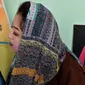 Foto yang diambil pada 5 Desember 2019 menunjukkan seniman Robaba Mohammadi melukis menggunakan mulut di studionya di Kabul. Untuk membuktikan bahwa stigma negatif tentang perempuan dan disabilitas salah, Robaba mengembangkan bakat di bidang seni lukis. (NOORULLAH SHIRZADA/AFP)