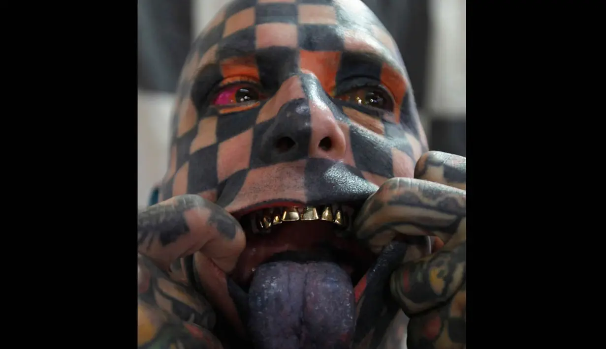 Matt Gone memperlihatkan lidahnya yang ditato serta gigi emas miliknya di acara Guate Mayan Tattoo Convention di Kota Guatemala, Sabtu (19/7/14). (REUTERS/Jorge Dan Lopez)