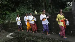 Sejumlah wanita saat akan beribadah di sekitar Sungai Yeh Sah, Desa Batusesa, Kec Rendang, Karangasem, Bali, Jumat (1/12). Warga berharap diberi keselamatan dan berkah dari erupsi Gunung Agung yang terjadi. (Liputan6.com/Immanuel Antonius)