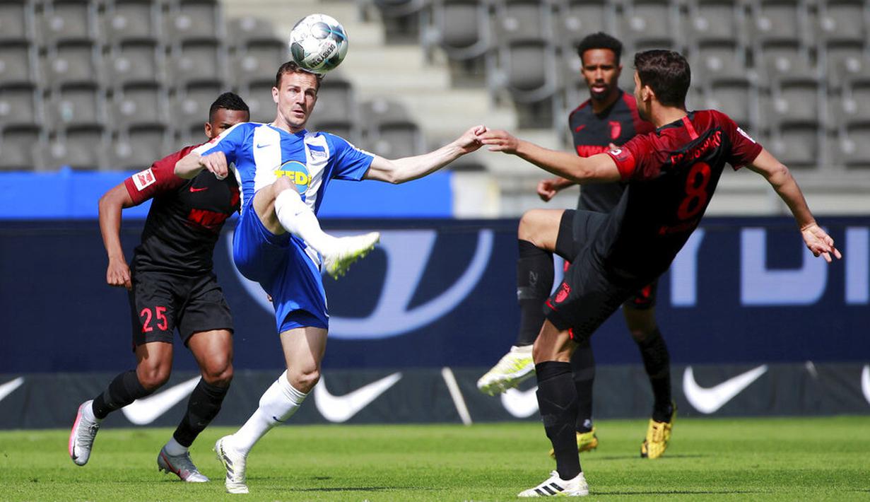 Pemain Hertha Berlin, Vladimir Darida, berebut bola dengan pemain Augsburg, Rani Khedira, pada laga Bundesliga di Olympiastadion, Sabtu (30/5/2020). Hertha Berlin menang 2-0 atas Augsburg. (AP/Hannibal Hanschke)