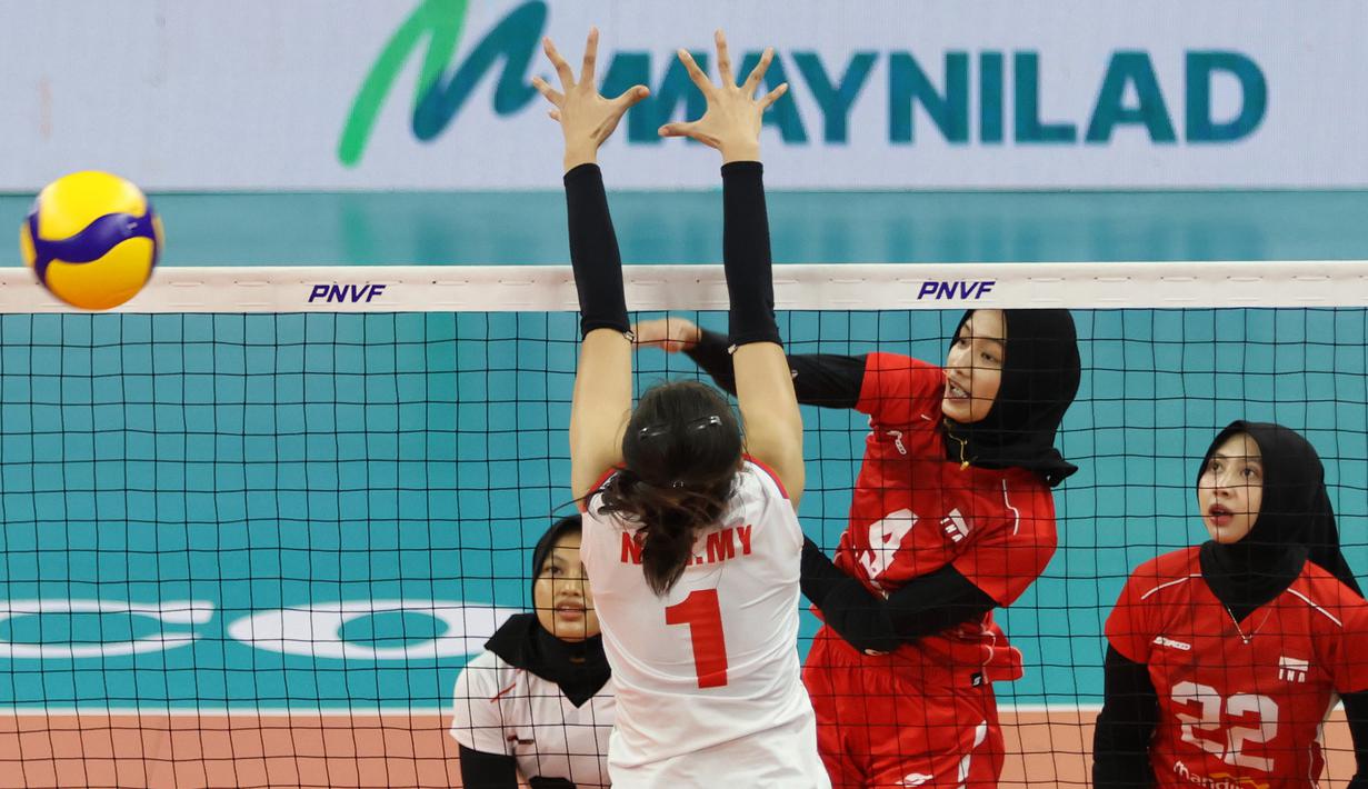 Pemain Timnas voli putri Indonesia, Bela Sabrina (tengah) melepaskan spike yang berhasil menembus blok pemain Vietnam, Nguyen Thi Tra My pada laga Grup B AVC Challenge Cup 2024 di Rizal Memorial Coliseum, Manila, Filipina, Minggu (26/5/2024). Indonesia kalah 1-3 (17-25, 15-25, 27-25 dan 13-25). (Asian Volleyball Confederation)