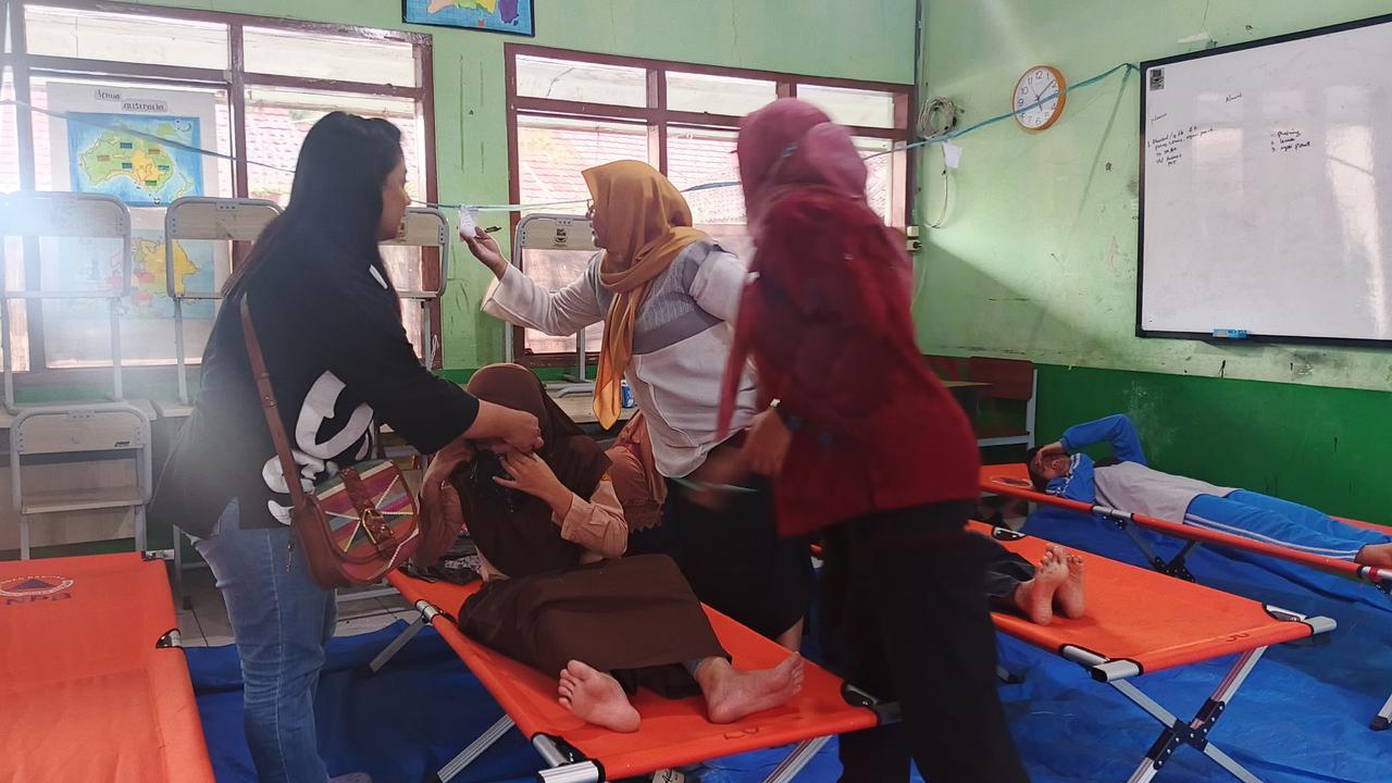 Siswa SMPN 1 Cisarua, KBB, mendapat penanganan medis di posko karena  mengalami gejala keracunan usai menyantap MBG, pada Selasa (14/10).