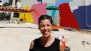 Seniman asal Brasil, Tarsila Schubert tersenyum di depan karya mural yang ia buat di Museum Seni Terbuka, Kota Amman, Yordania, Kamis (29/9). (REUTERS/Muhammad Hamed)