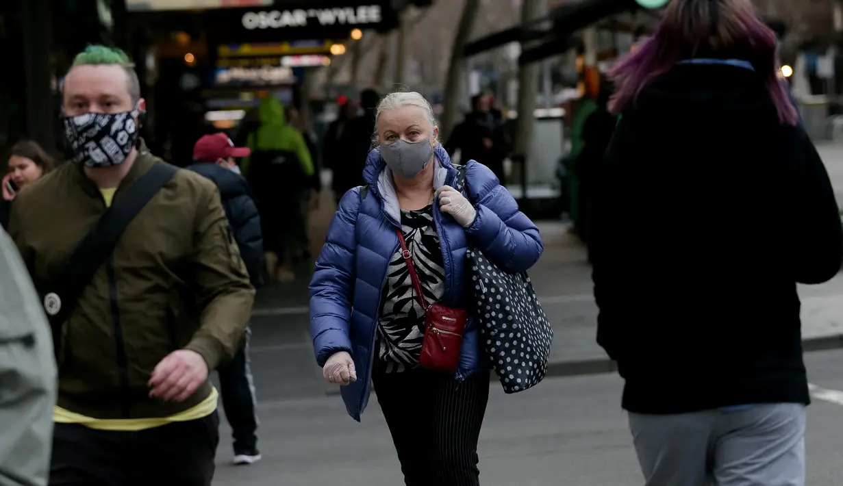 Orang-orang berjalan di sepanjang jalan di pusat kota Melbourne ketika pihak berwenang mengumumkan lockdown untuk keenam kalinya di kota itu, pada Kamis (5/8/2021).  Lockdown di kota terpadat kedua di Australia tersebut guna mengendalikan penyebaran Covid-19 varian delta. (Con Chronis/AFP)