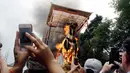 Wisatawan mengambil gambar  bade yang berisi tubuh Anak Agung Niang Agung terbakar saat ngaben keluarga Kerajaan Puri Ubud di Bali, Indonesia, Jumat (2/3). Anak Agung Niang Agung meninggal dunia Januari lalu di usia 96 tahun. (AP Photo/Firdia Lisnawati)