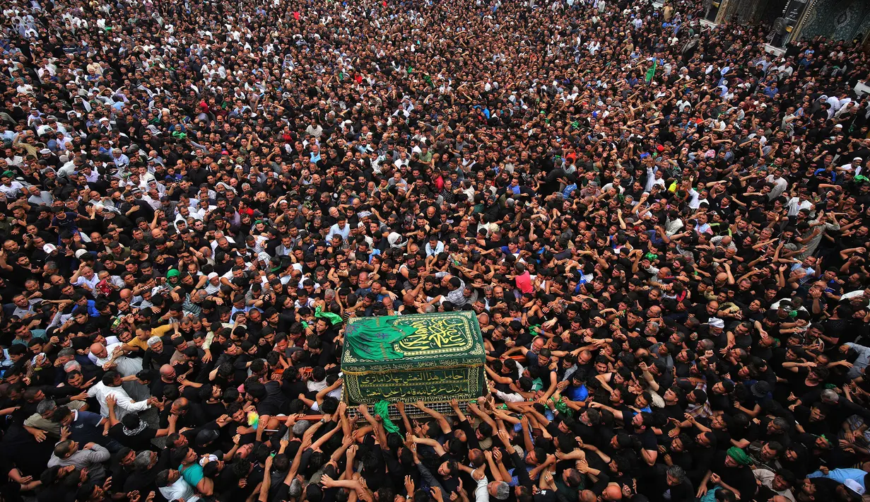 Umat Syiah Irak membawa peti jenazah saat memperingati wafatnya Imam Musa al-Kadhim di Kadhimiya, Irak (12/4). Musa al-Kadhim adalah putra dari Imam ke-6, Ja'far ash-Shadiq. (AFP Photo/Ahmad Al-Rubaye)