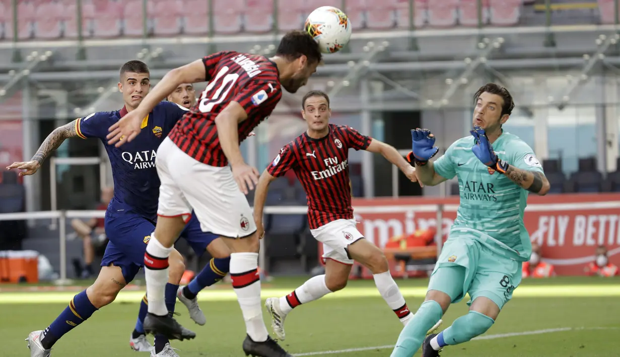 Pemain AC Milan Hakan Calhanoglu menyundul bola ke gawang AS Roma pada pertandingan Serie A di Stadion San Siro, Milan, Minggu (28/6/2020). AC Milan naik ke posisi 7 klasemen dengan 42 poin usai mengalahkan AS Roma 2-0. (AP Photo/Luca Bruno)