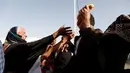 Seorang warga berebut sepotong roti saat mengungsi di kamp Khazer, Irak, (11/11). Mereka terpaksa melarikan diri dari kampung halamannya saat Pasukan Irak dan kelompok militan ISIS bentrok. (REUTERS/Zohra Bensemra)