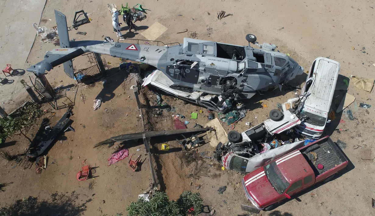 Foto dari atas menunjukkan kondisi helikopter milter UH-60 Black Hawk yang jatuh di Santiago Jamiltepec, negara bagian Oaxaca, Meksiko, Sabtu (17/2). Helikopter militer itu terguling ke samping, dikelilingi sejumlah kendaraan. (MARIO VAZQUEZ/AFP)