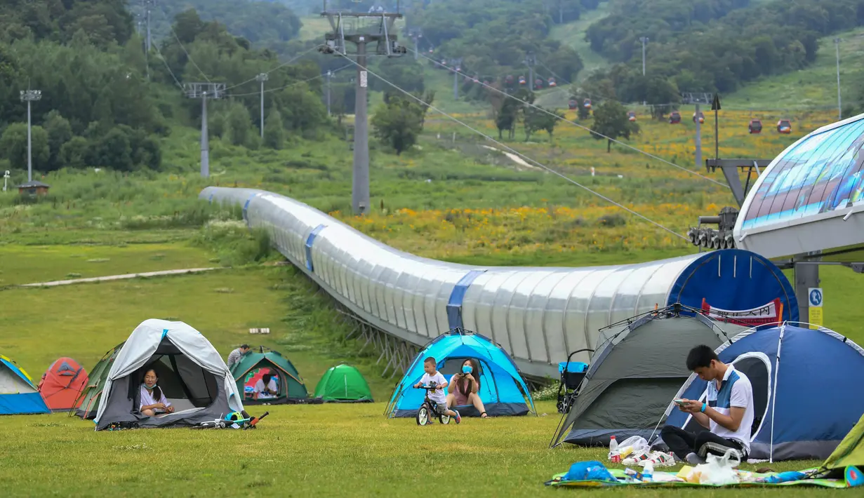Warga berkemah di sebuah kawasan resor di Kota Jilin, Provinsi Jilin, China pada 19 Juli 2020. Arena ski di kawasan resor itu diubah menjadi ladang bunga, seluncuran, dan beragam proyek pariwisata rekreasi lainnya guna menarik wisatawan pada musim panas. (Xinhua/Yan Linyun)