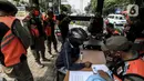 Petugas mendata warga pelanggar Pembatasan Sosial Berskala Besar (PSBB) yang terjaring razia masker di wilayah Tanah Abang, Jakarta, Senin (14/9/2020). Razia tersebut guna menekan kasus penyebaran COVID-19 di Jakarta pada masa PSBB. (Liputan6.com/Johan Tallo)