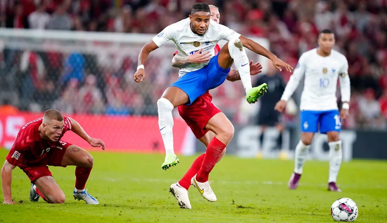 Pemain Denmark Simon Kjaer (tengah belakang) mengangkat pemain Prancis Christopher Nkunku pada pertandingan sepak bola UEFA Nations League di Parken Stadium, Kopenhagen, Denmark, 25 September 2022. Denmark mengalahkan Prancis dengan skor 2-0. (Mads Claus Rasmussen/Ritzau Scanpix via AP)