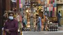 Seorang pria duduk di depan toko suvenir di Deira Souk di kota Emirat Dubai (30/9/2020). (AFP/Karim Sahib)